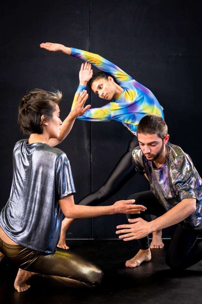 Photo d'une représentation de "Planète". Trois danseurs(euses) créant des formes géométrique avec leurs bras et leurs corps.