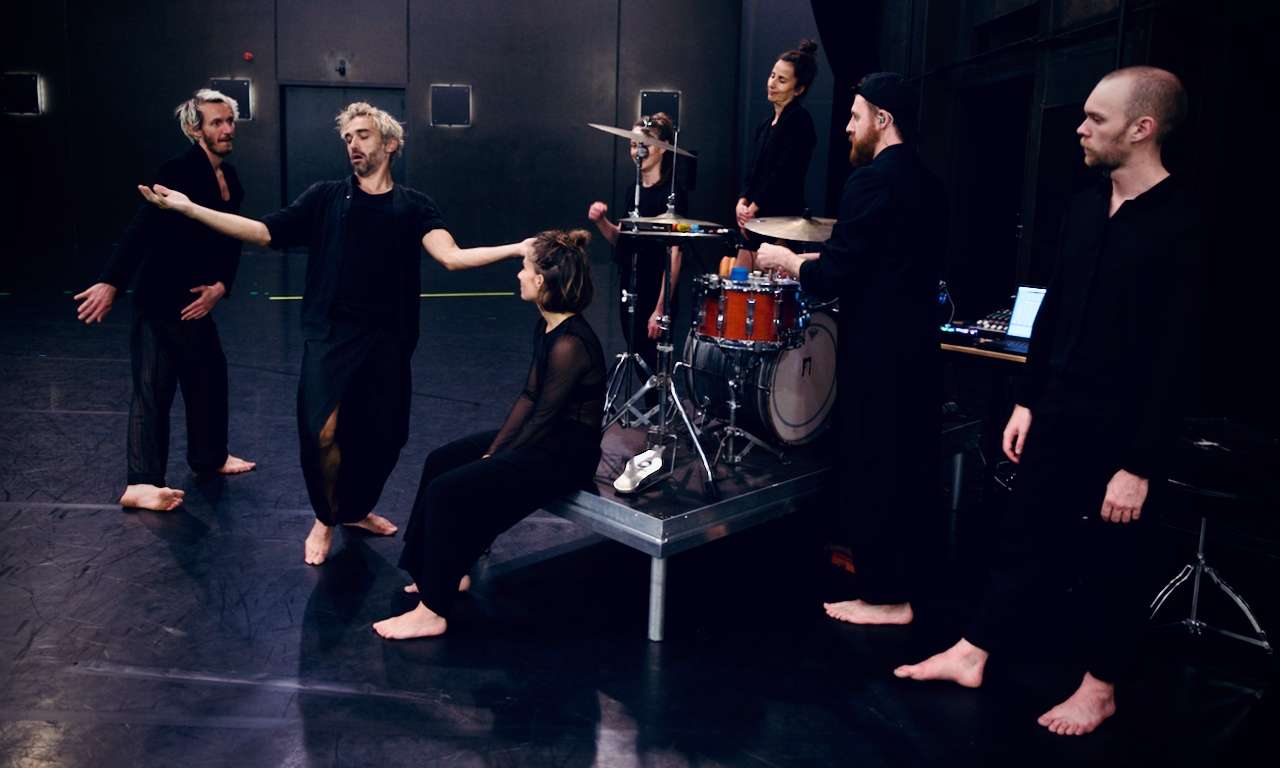 Photo d'une des représentations de "The Way Things Go". Les six danseurs(euses) se retrouvent avec le musicien. Un des danseurs se met à danser pendant que les autres le regarde.